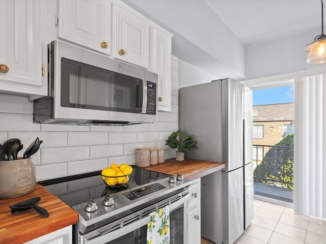 kitchen with light tile patterned floors, stainless steel appliances, wood counters, white cabinets, and decorative backsplash