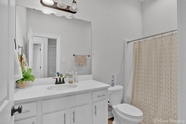 bathroom with curtained shower, vanity, and toilet