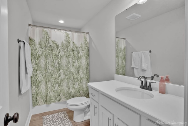 full bathroom with toilet, wood finished floors, shower / bath combo with shower curtain, vanity, and recessed lighting