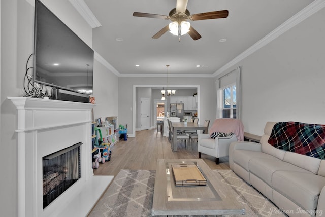 living room with a fireplace with raised hearth, baseboards, wood finished floors, and crown molding