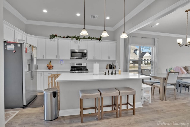 kitchen featuring appliances with stainless steel finishes, visible vents, light wood-style flooring, and decorative backsplash