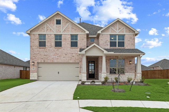 view of front of home featuring a shingled roof, fence, a front lawn, and brick siding