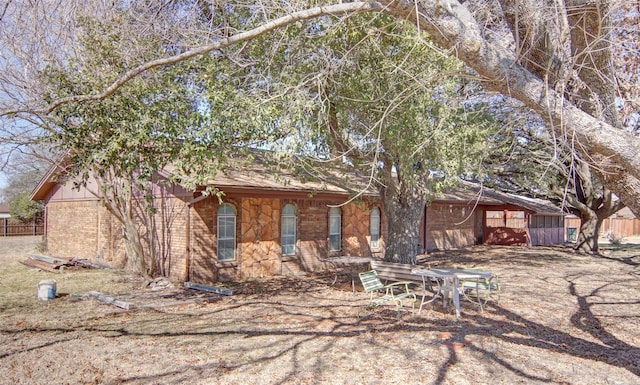 view of front facade with brick siding and fence