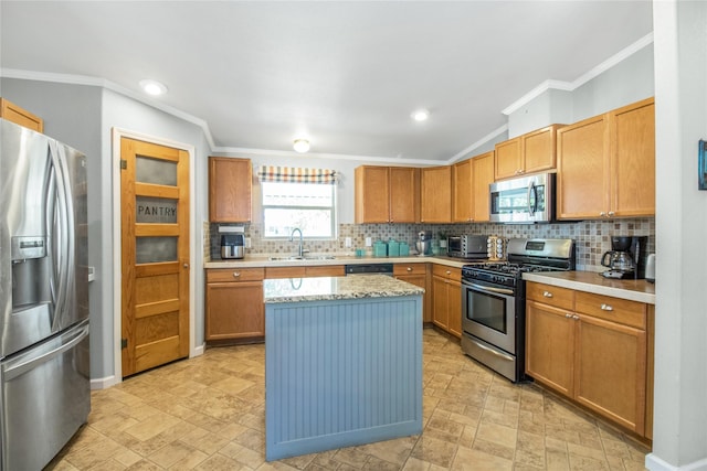 kitchen with a sink, appliances with stainless steel finishes, backsplash, a center island, and crown molding