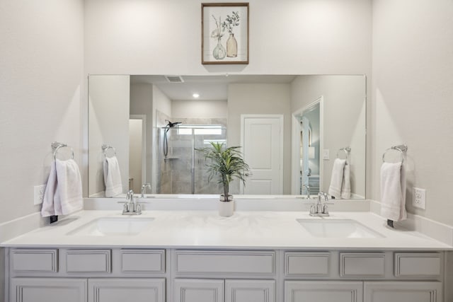 bathroom featuring double vanity, a sink, visible vents, and a shower stall