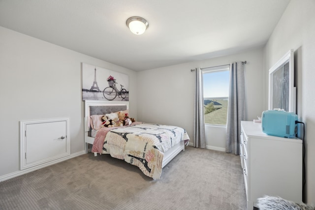 bedroom with light carpet and baseboards