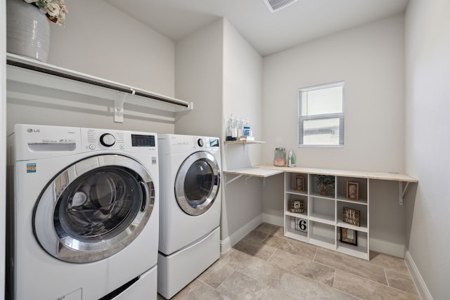 washroom with washing machine and dryer, laundry area, visible vents, and baseboards