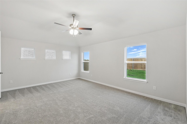 carpeted empty room with a ceiling fan and baseboards