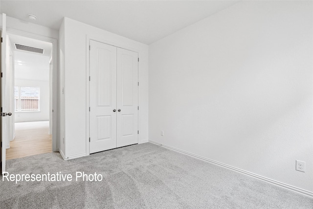 unfurnished bedroom featuring a closet, visible vents, baseboards, and carpet flooring