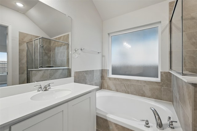 full bath featuring a bath, a shower stall, lofted ceiling, and vanity