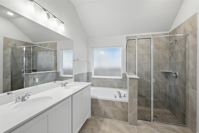 bathroom featuring vaulted ceiling, a stall shower, and a sink