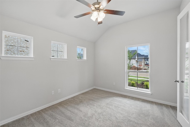 spare room with carpet, vaulted ceiling, baseboards, and ceiling fan