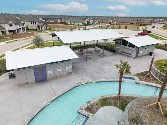 pool featuring a residential view, cooling unit, and fence