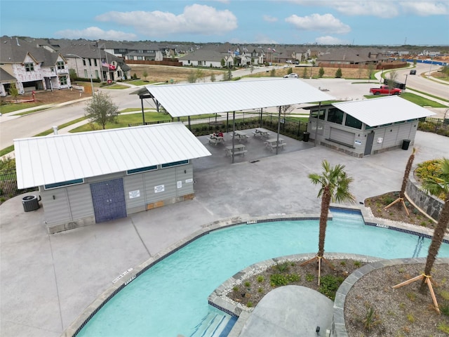 pool featuring central air condition unit, a patio, a residential view, and fence