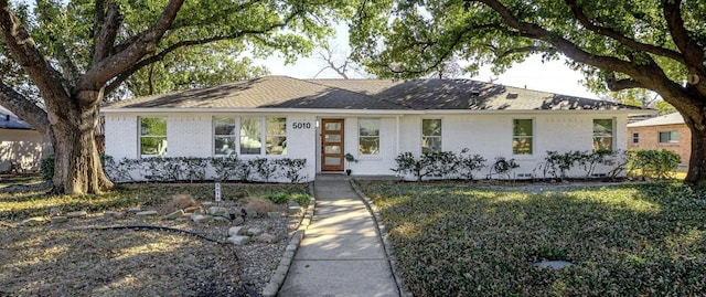 single story home featuring brick siding