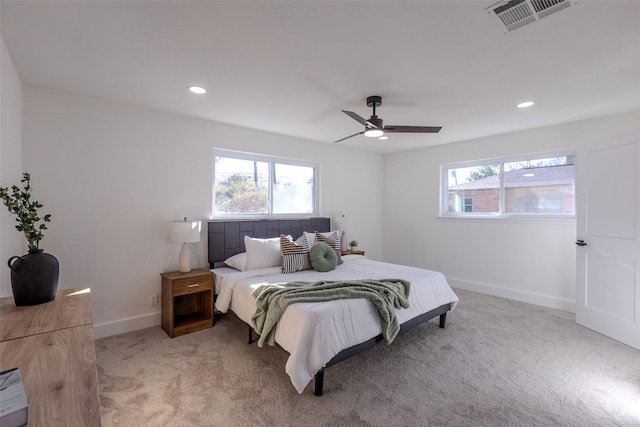 bedroom with baseboards, multiple windows, visible vents, and light colored carpet