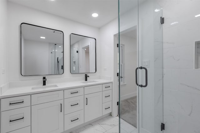 bathroom with marble finish floor, a sink, a shower stall, and double vanity