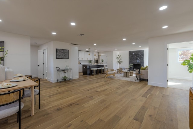 living area featuring a fireplace, light wood-style flooring, and recessed lighting