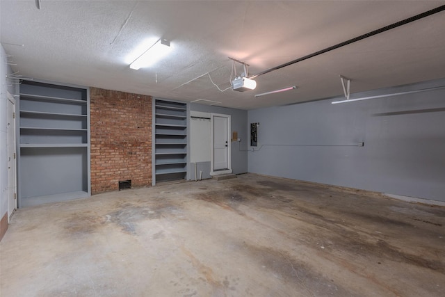 garage featuring electric panel and a garage door opener