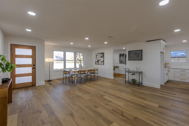 dining room with light wood finished floors, baseboards, visible vents, and recessed lighting