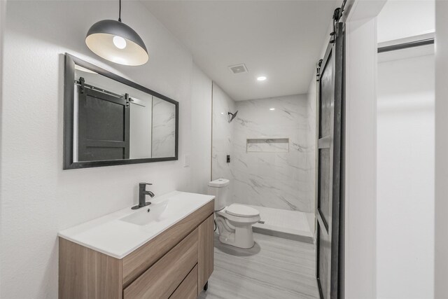 bathroom featuring a marble finish shower, visible vents, toilet, vanity, and recessed lighting