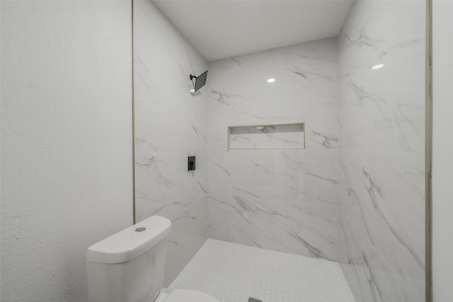 bathroom with a marble finish shower and toilet