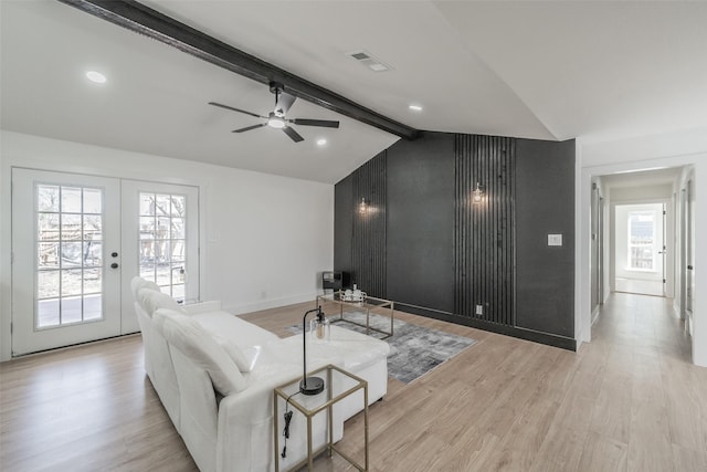 living area featuring baseboards, visible vents, vaulted ceiling with beams, french doors, and light wood-style floors