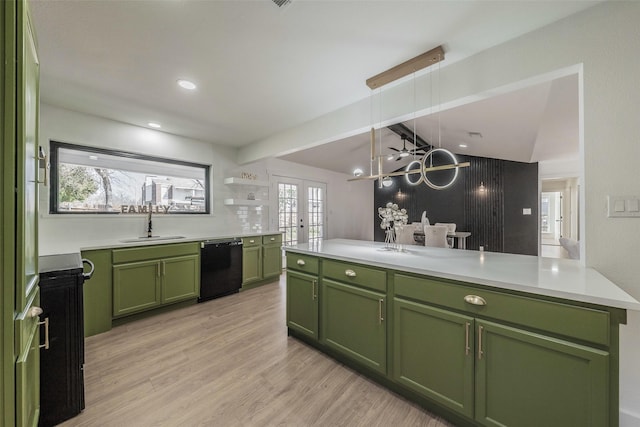 kitchen with light wood finished floors, dishwasher, light countertops, green cabinets, and a sink