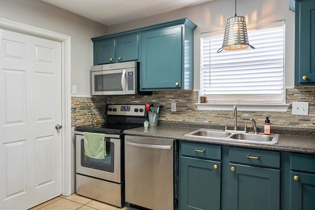 kitchen with appliances with stainless steel finishes, dark countertops, a sink, and backsplash