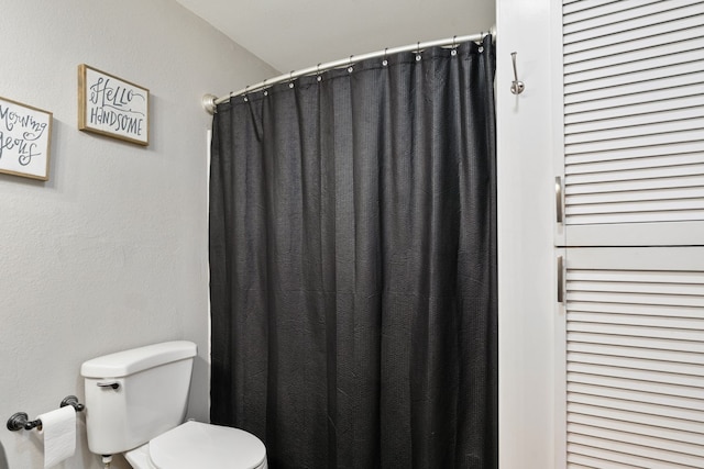 bathroom featuring toilet and a shower with curtain