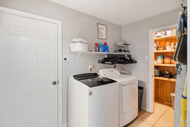 clothes washing area featuring laundry area, independent washer and dryer, and light tile patterned floors