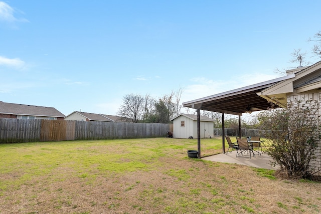 view of yard featuring a patio, ceiling fan, a fenced backyard, a storage unit, and an outdoor structure