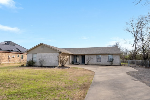 view of front of property featuring driveway, a front lawn, an attached garage, and brick siding