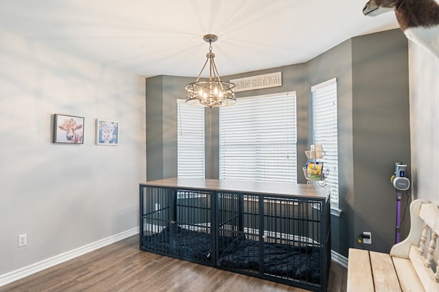 dining room with a chandelier, wood finished floors, and baseboards