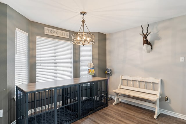 interior space featuring an inviting chandelier, baseboards, and wood finished floors