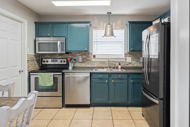 kitchen featuring light tile patterned floors, decorative backsplash, dark countertops, stainless steel appliances, and a sink