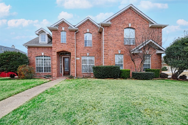 view of front facade featuring a front yard and brick siding