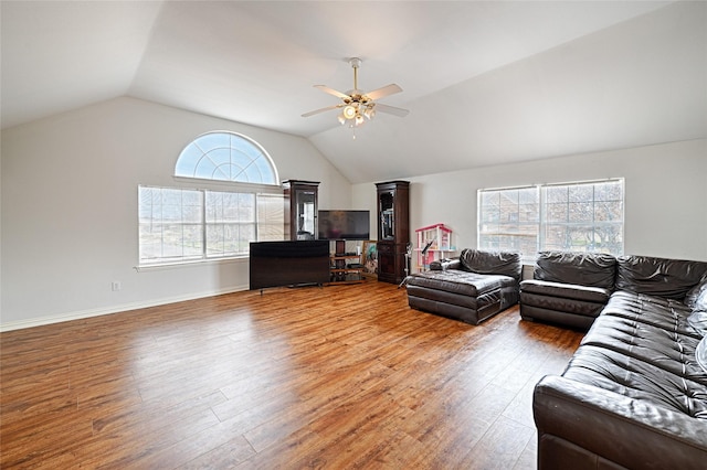 living room with lofted ceiling, ceiling fan, wood finished floors, and baseboards