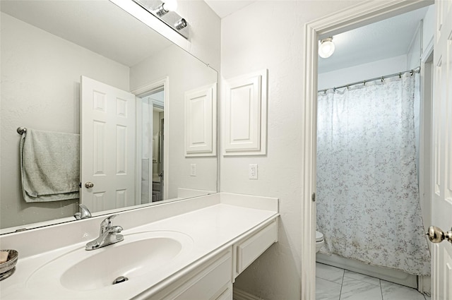 full bath with toilet, marble finish floor, and vanity