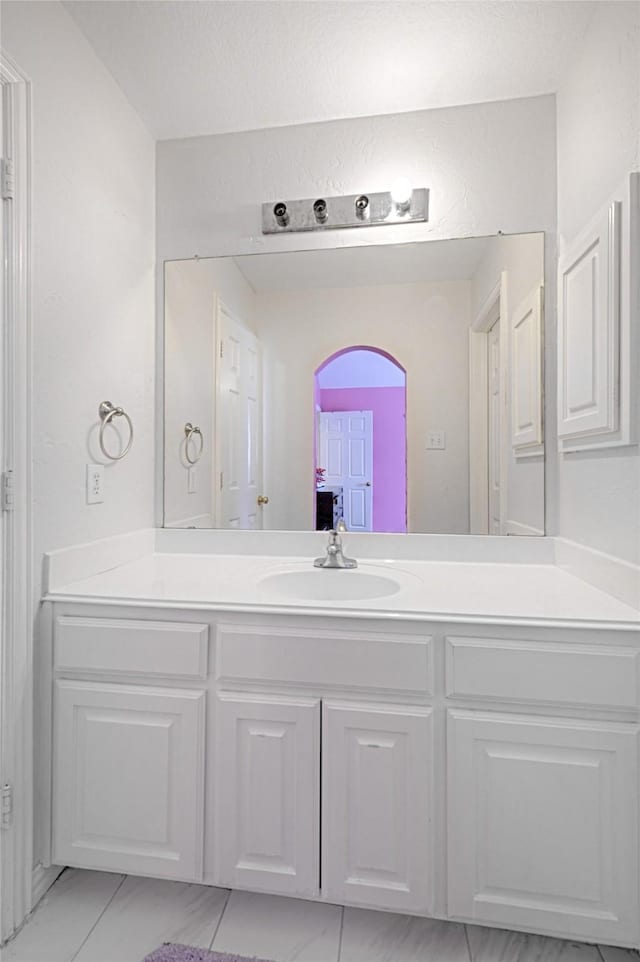 bathroom featuring marble finish floor and vanity