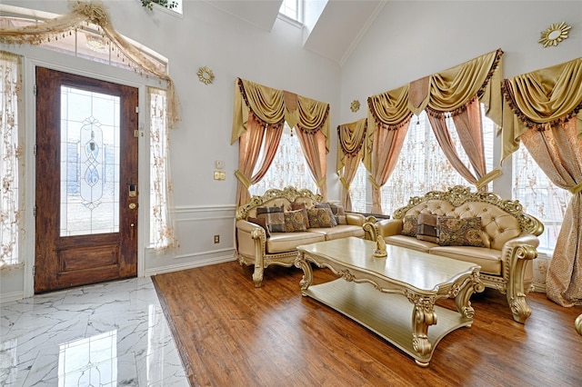 sitting room with marble finish floor and high vaulted ceiling