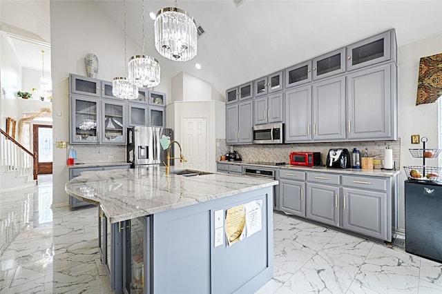 kitchen with a chandelier, gray cabinetry, a sink, marble finish floor, and appliances with stainless steel finishes