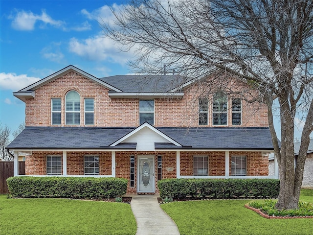 traditional-style home featuring brick siding, a shingled roof, and a front lawn