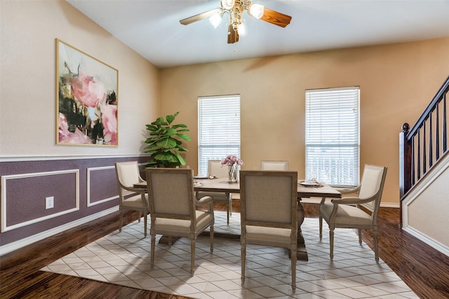 dining room with stairs, ceiling fan, a healthy amount of sunlight, and light wood-style flooring