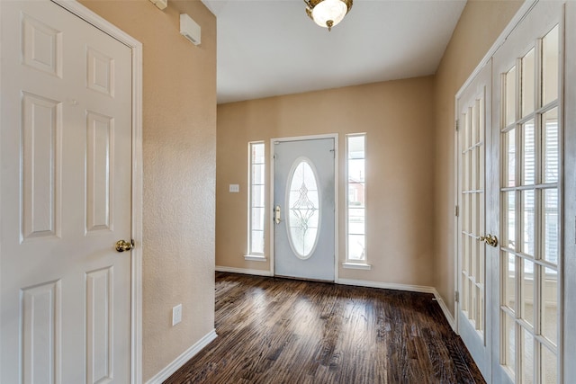 foyer entrance with dark wood-style flooring and baseboards