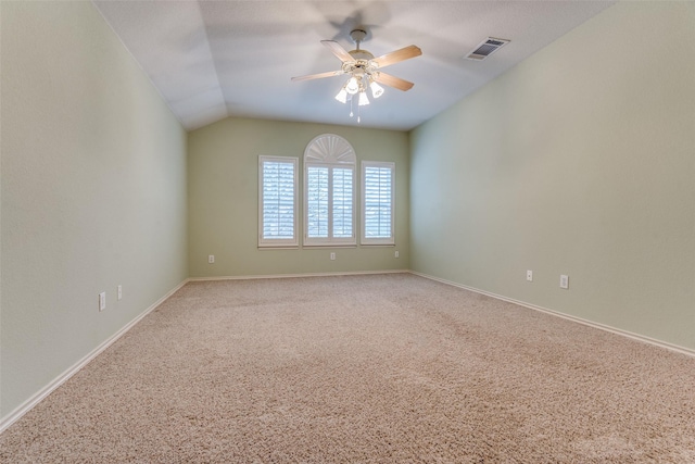 spare room featuring ceiling fan, lofted ceiling, visible vents, baseboards, and carpet