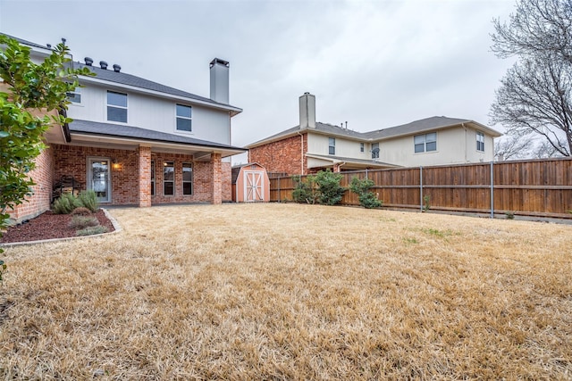 back of property with an outbuilding, brick siding, fence, and a storage shed