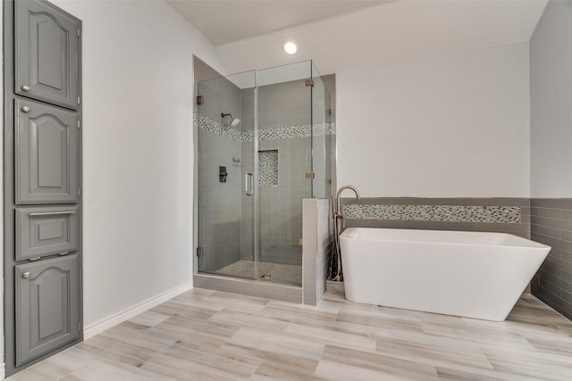 full bathroom with a stall shower and a freestanding tub