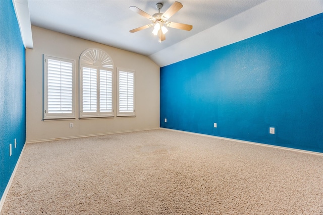 unfurnished room with lofted ceiling, ceiling fan, and baseboards