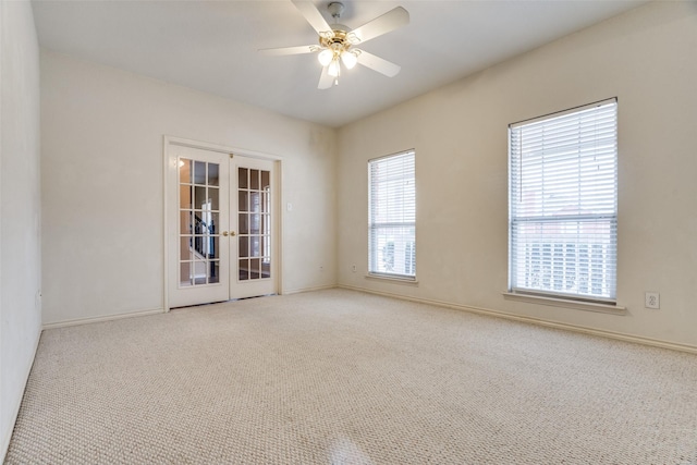 carpeted empty room with french doors, ceiling fan, and baseboards